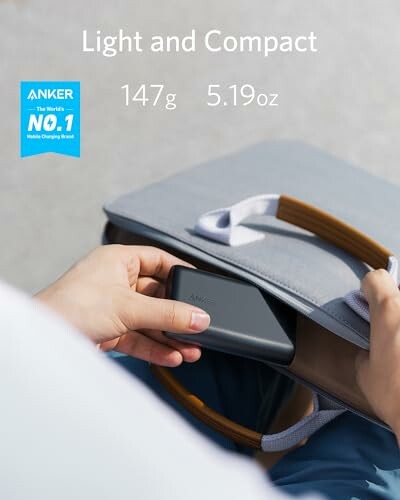 Person placing Anker power bank into a bag, labeled light and compact, 147g 5.19oz.