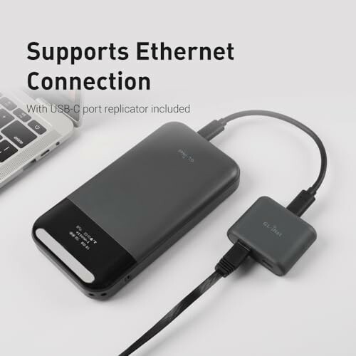 Ethernet adapter with USB-C port replicator connected to a laptop.