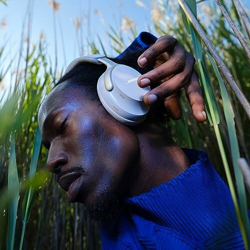 Man in blue shirt wearing headphones in nature