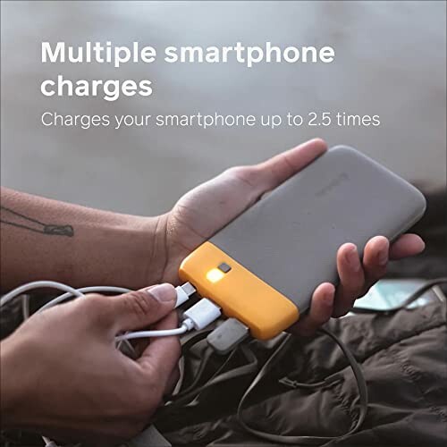 Person holding a power bank charging multiple devices.