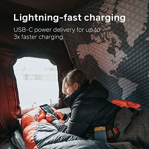 Person in a sleeping bag using a smartphone with text about USB-C fast charging.